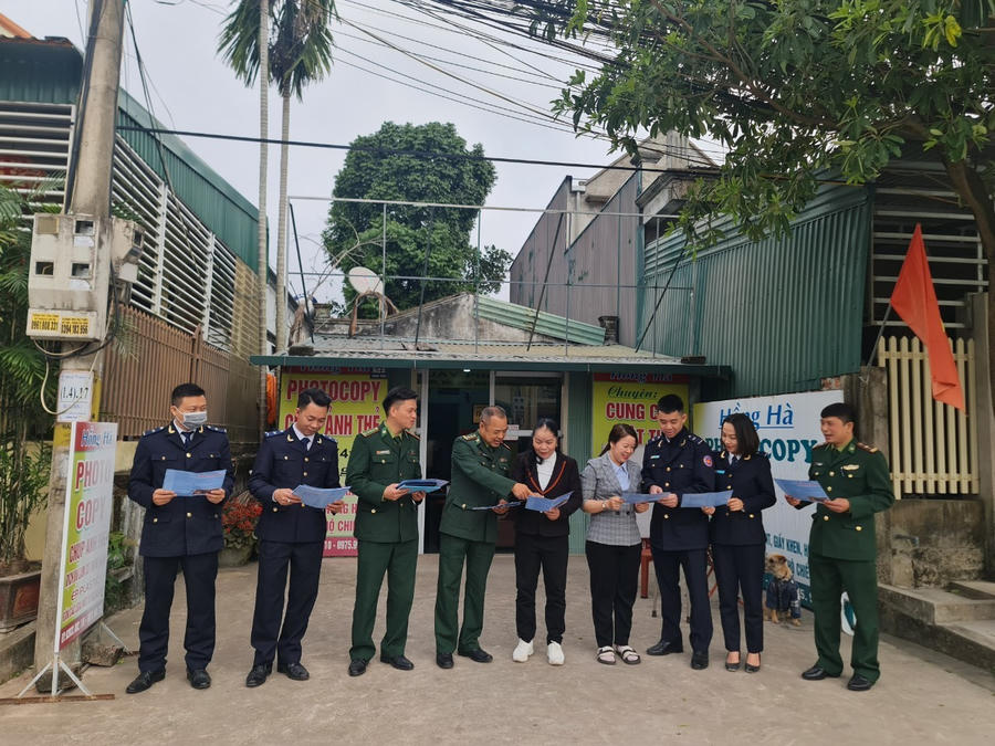 Cán bộ các lực lượng và một số nhân dân khu vực biên giới trao đổi về các nội dung pháp luật phổ biến trong tờ rơi.