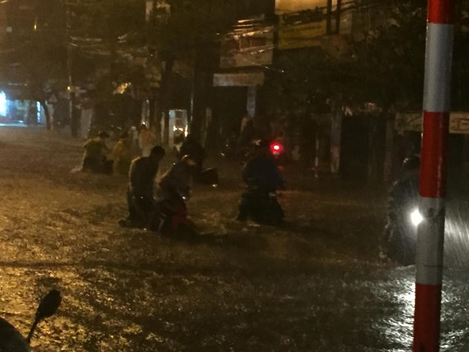 Người dân khổ sở vật lộn với phương tiện của mình giữa dòng nước.