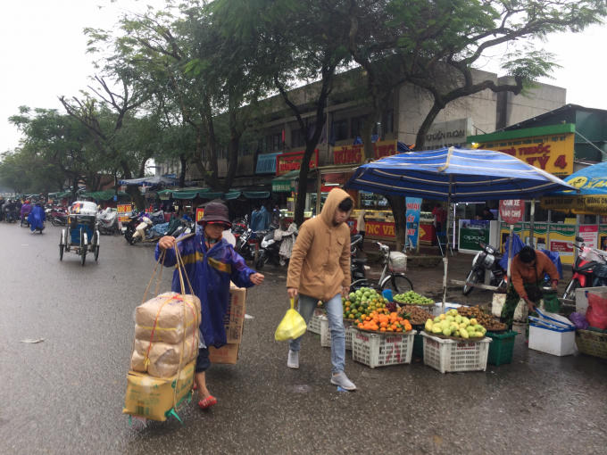 Mưa, lạnh nhưng công việc buôn bán không ngừng nghỉ ( Ảnh: Thân Hiền)