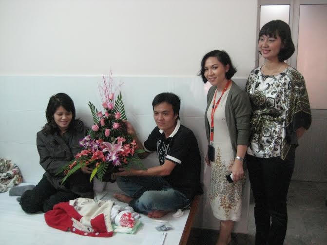 Đại diện Jetstar Pacific thăm và tặng hoa cho chị Nguyễn Thị Lập sinh bé trai trên máy bay năm 2011.