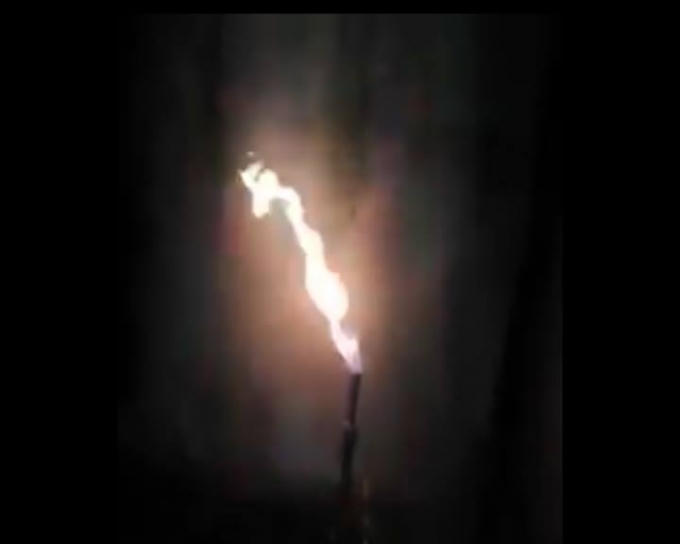 Luồng khí lạ thoát ra từ miệng giếng khoan bùng cháy khi châm lửa.