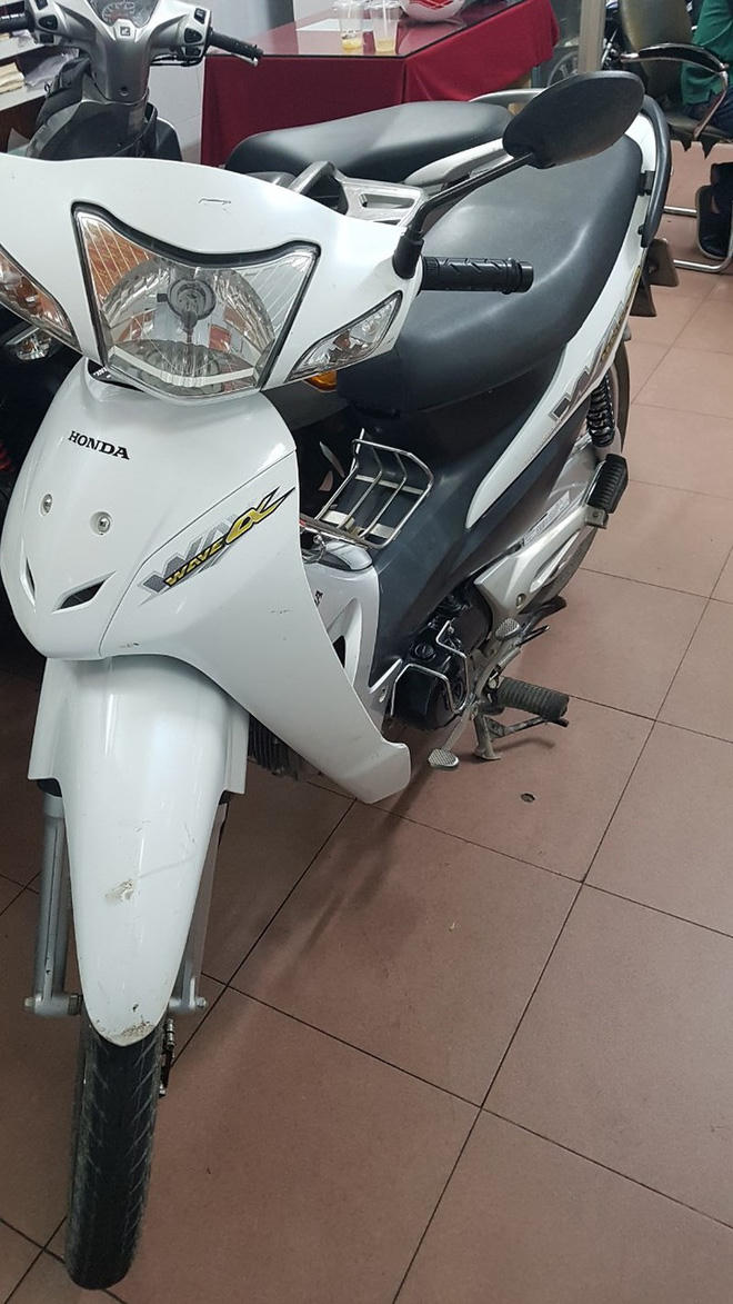 Chiếc xe máy của người đàn ông nằm ngủ ơ rnhaf chờ xe buýt.