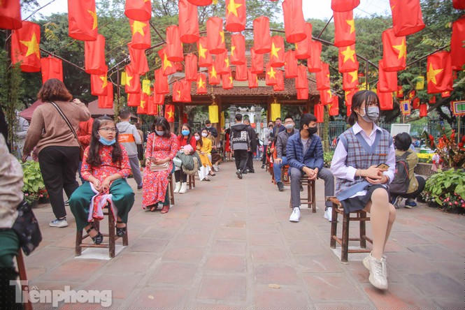 Vì lượng ông đồ ít nên người dân phải xếp hàng chờ đợi, ghế chờ được xếp sẵn giữ khoảng cách tối thiểu 1m.