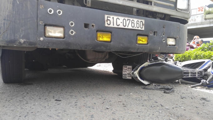 Chiếc xe máy nằm dưới bánh xe container