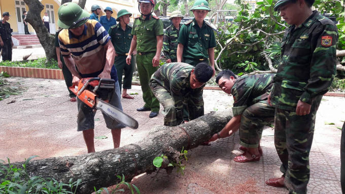 Lực lượng chức năng cắt bỏ những cây bị gãy, đổ tại trường tiểu học phường Nghi Hải, thị xã Cửa Lò.