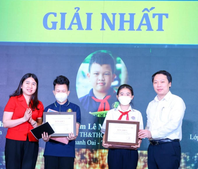 Ông Nguyễn Huy Dũng, Thứ trưởng Bộ TT&TT và bà Nguyễn Thị Nga, Phó Cục trưởng Cục Trẻ em (Bộ LĐTBXH) trao giải Nhất cho 3 học sinh.