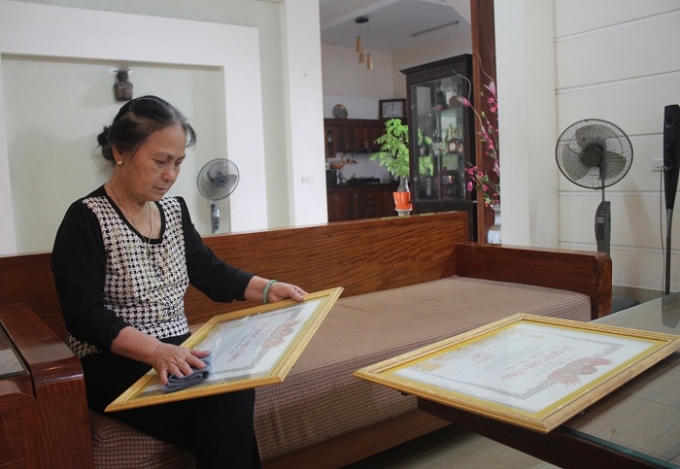 Bà Nguyễn Thị Huệ lau thật sạch tấm bằng Tổ quốc ghi công của người chú và em chồng trước ngày giỗ.