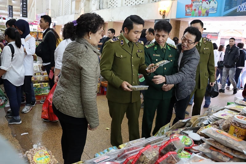 Đoàn kiểm tra tại 1 cửa hàng kinh doanh bánh, mứt, kẹo... trong chợ Đồng Xuân. Ảnh: T.Bình