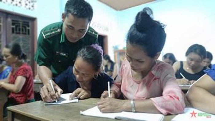 Trung úy Hồ Văn Lăng hướng dẫn học viên lớp học chống tái mù chữ ở thôn A Ho.