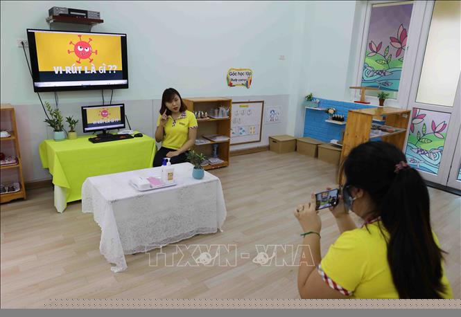 Giáo viên trường Mầm non Thanh Xuân Trung làm bài giảng điện tử dạy học sinh cách phòng chống virus. Ảnh: Thanh Tùng/TTXVN