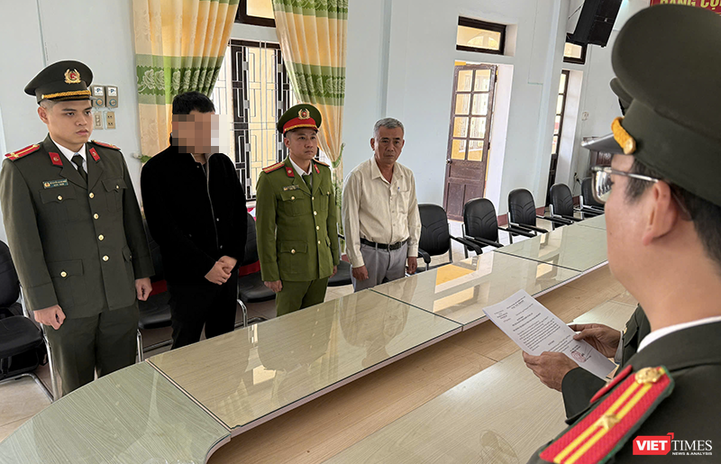 Hoàng Trung Nghĩa (áo đen) tại cơ quan điều tra.