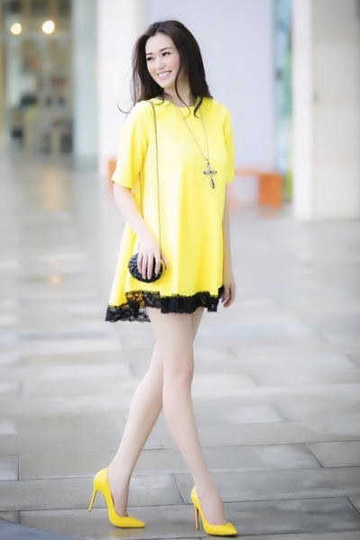 Chiếc váy màu vàng thêm phần ren màu đen, kết hợp với chiếc túi xách nhỏ màu đen trông bạn thật nổi bật và sành điệu. Ảnh: internet.
