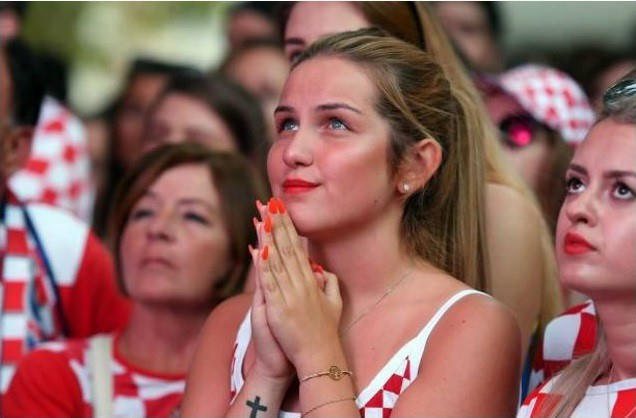 Nữ cổ động viên cầu nguyện trong suốt thời điểm trận đấu diễn ra