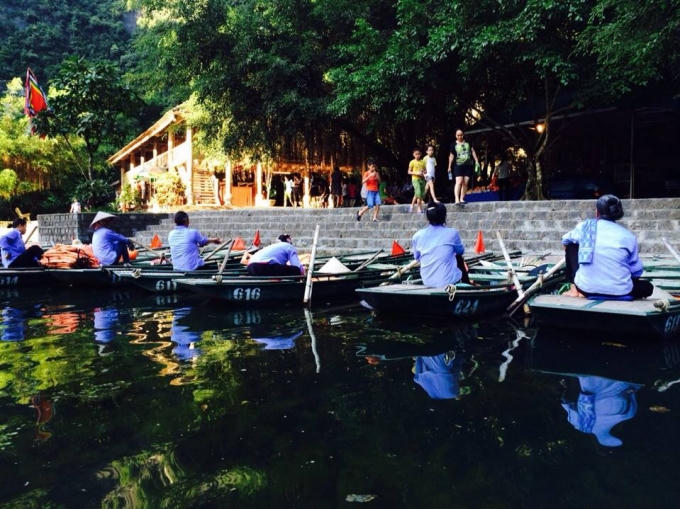 Những người chèo thuyền ngồi trên bờ đợi khách du lịch.