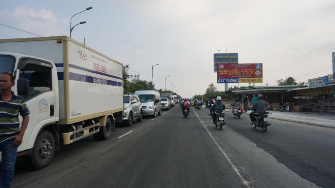Xe tải từ các tỉnh về TP HCM ùn ứ xếp hàng dài 4-5 Km rừ 2 bên cầu.