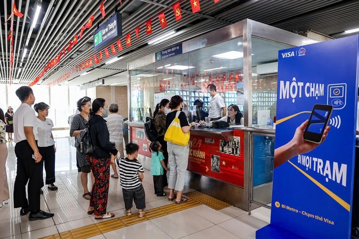 Hành khách thực hiện soát vé, thanh toán một chạm bằng thẻ ngân hàng, ứng dụng vé điện tử. (Ảnh: HanoiGov)