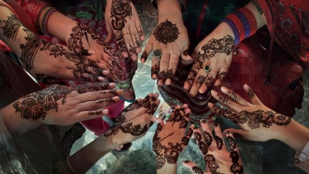 Phụ nữ Pakistan vẽ những hoa văn Henna truyền thống lên tay trước ngày lễ Eid al-Fitr. (Ảnh: AP)