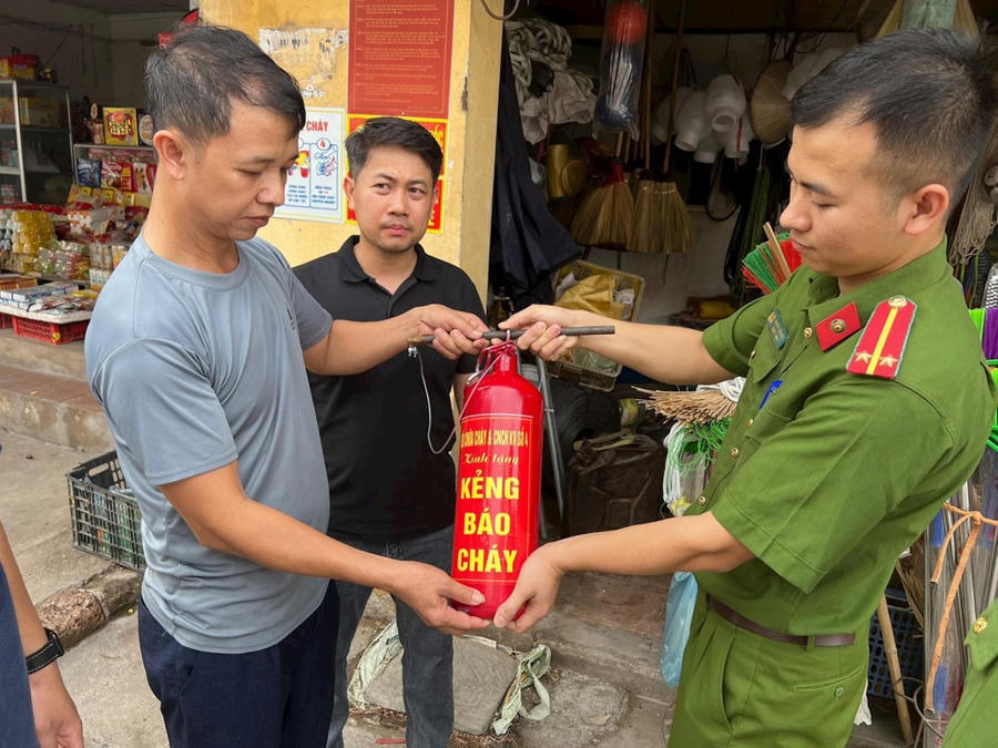 Tặng kẻng báo cháy cho người dân.