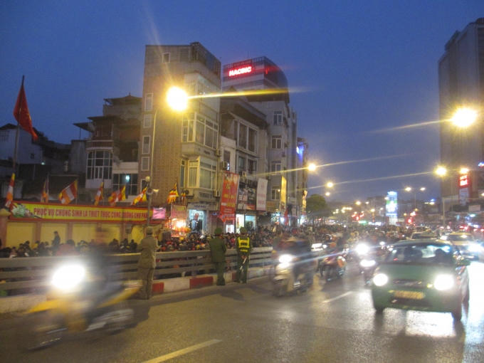 Lực lượng công an phải đứng ra phân luồng tránh tình trạng tắc đường, các phương tiện giao thông đều được hướng dân đi lên cầu Ngã Tư Sở. (Ảnh: Thu Hường)