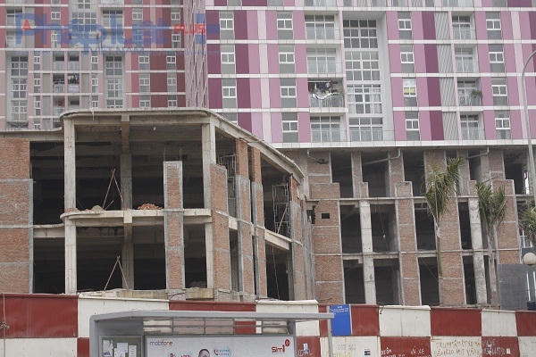 Dưới chân của 3 tòa nhà chưa được hoàn thiện, trơ gạch, xi măng.