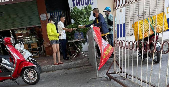 Người đàn ông trung niên mặc áo trắng không đeo khẩu trang tại chốt kiểm dịch, được cho là Bí thư Đảng ủy phường Tân Mai, quận Hoàng Mai.