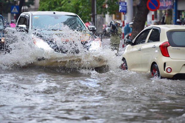 Nước mưa bắn tung tóe khi xe ô tô lưu thông với tốc độ cao.