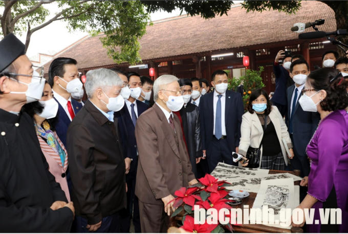 Tổng Bí thư Nguyễn Phú Trọng nghe giới thiệu quy trình làm tranh dân gian Đông Hồ. (Ảnh: bacninh.gov.vn)