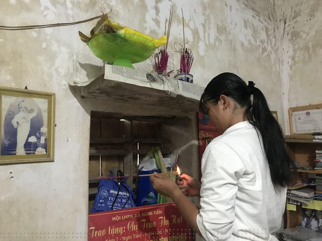 Ngọc thắp hương lên bàn thờ của gia đình trước khi lên xe ra trường nhập học.