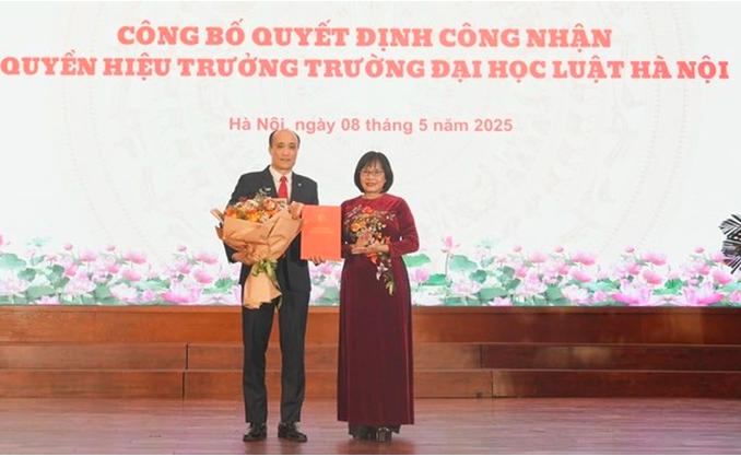 Thứ trưởng Bộ Tư pháp Đặng Hoàng Oanh trao quyết định cho ông Tô Văn Hòa, quyền Hiệu trưởng Trường Đại học Luật Hà Nội.