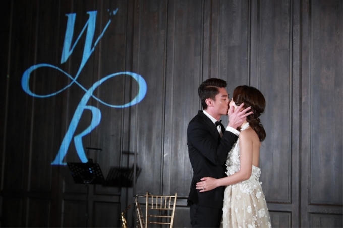 Cặp đôi hạnh phúc trao nhau nụ hôn trong bữa tiệc.