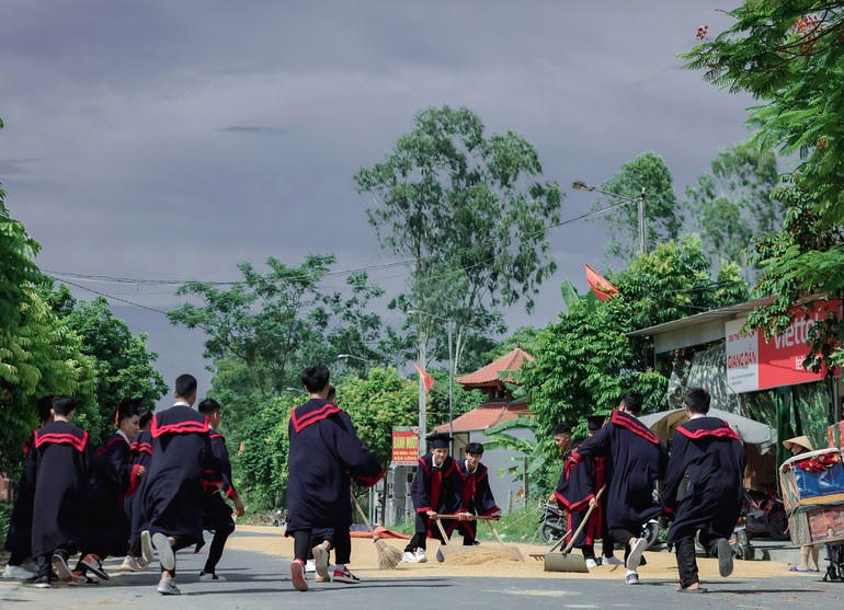 Sau đó cả lớp ùa ra sân phơi, giúp nhà dân thu dọn lúa tránh mưa (Ảnh: Team Nhện).