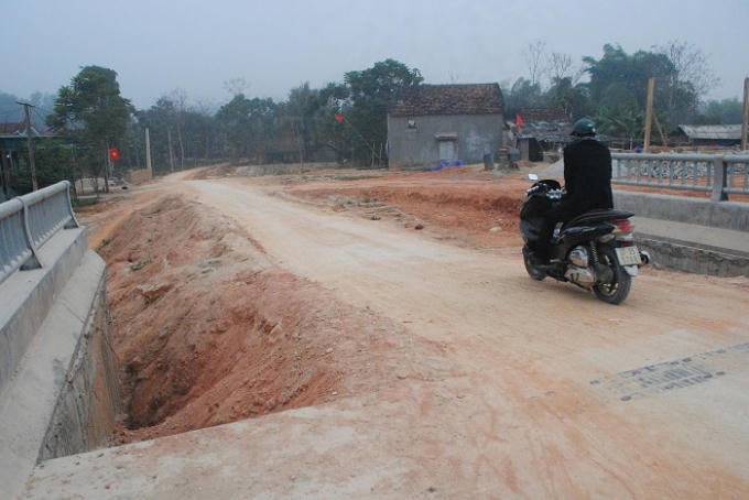Đường dẫn lên cầu được đắp sơ sài, vô tình tạo thành những cái bẫy rất nguy hiểm cho người và phương tiện qua đây. (Ảnh: Duy Ngợi).