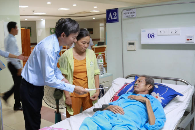 Ông Trần Đình Nhân - Chủ tịch kiêm Tổng Giám đốc EVNCPC thăm hỏi một bệnh nhân tại bệnh viện.
