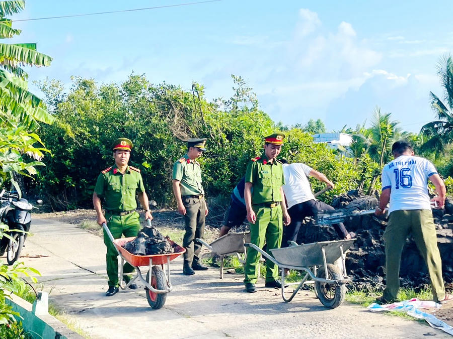 Cán bộ, chiến sĩ Công an tỉnh Cà Mau hỗ trợ đẩy đất, đắp nền nhà cho hộ ông Nguyễn Bình Em (ấp 1, xã Trí Phải).