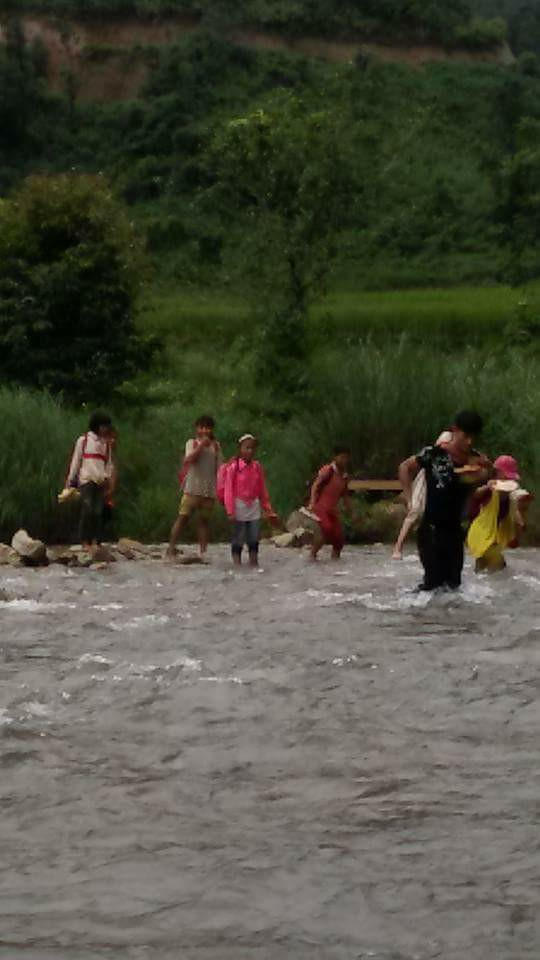 Thầy giáo cõng học trò nhỏ vượt suối.