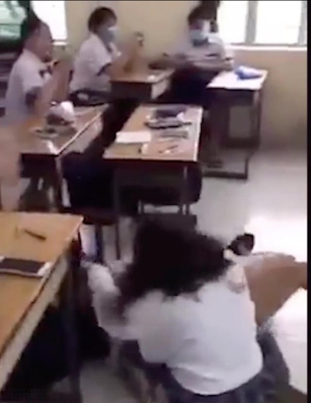 Một nhóm học trò ngồi nhắn tin, xem điện thoại, dửng dưng với cảnh tượng