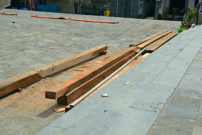 Gỗ thanh chuẩn bị cho gian hàng trưng bày được vứt bừa bãi dưới sân.