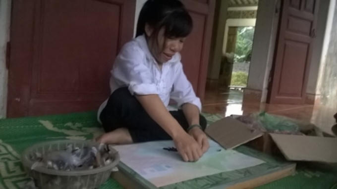 Vân đang tỉ mỉ ghép từng chiếc lông gà cho bức tranh của mình