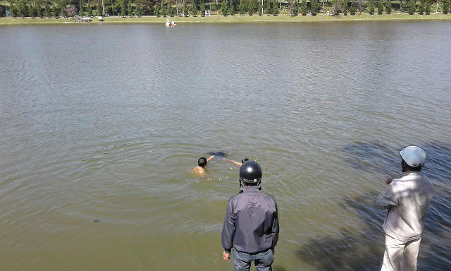 Một số người dân tiến hành trục vớt nạn nhân lên bờ. (Ảnh: báo Dân Việt)