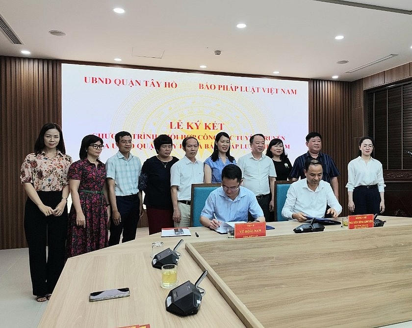 Đại diện UBND quận Tây Hồ và Báo Pháp luật Việt Nam ký kết chương trình phối hợp công tác tuyên truyền. (Ảnh: PV)