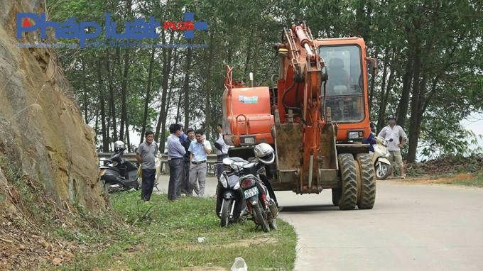 Ông Bùi Văn Bẩy - Phó Chủ tịch UBND xã Vụ Quang, trực tiếp chỉ đạo máy móc xe cộ nhân lực dọn xác lợn thối tại hiện trường.