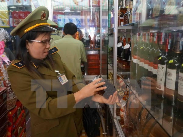 Lực lượng quản lý thị trường kiểm tra một cửa hàng kinh doanh rượu. Ảnh: Phạm Cường/TTXVN