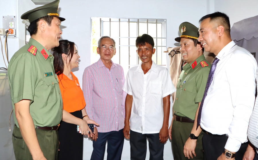 Ông Nguyễn Văn Bi (áo trắng, đứng giữa) phấn khởi dẫn các đại biểu Bộ Công an và lãnh đạo tỉnh Bạc Liêu tham quan căn nhà mới vừa được trao tặng.