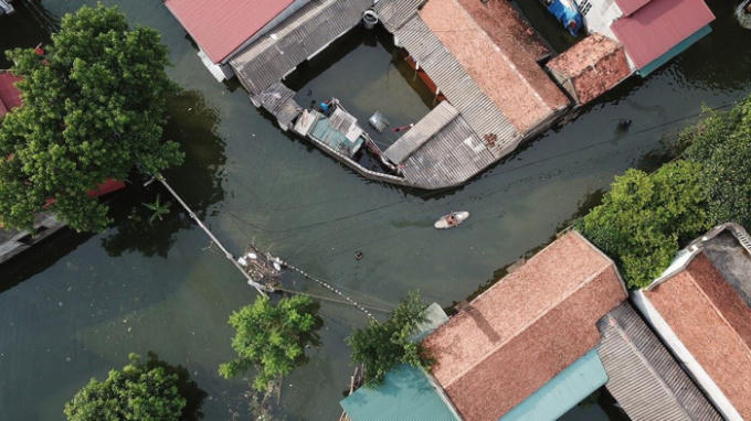 Một chiếc thuyền len lỏi trên đường làng như đi trên mặt sông. 