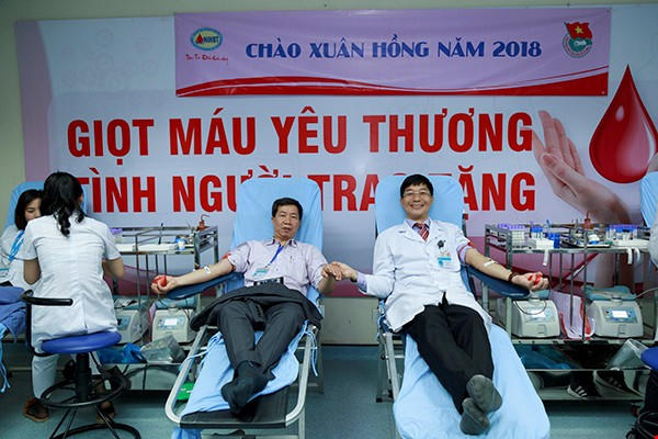 TS.BS Trần Ngọc Quế (bên phải) hiến máu tại buổi lễ Chào Xuân Hồng năm 2018.