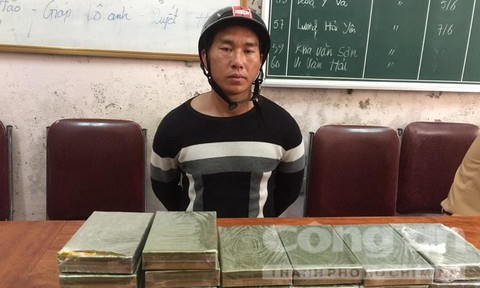 Xồng Bá Tênh cùng tang vật 20 bánh heroin. (Ảnh: báo Pháp luật TP HCM)