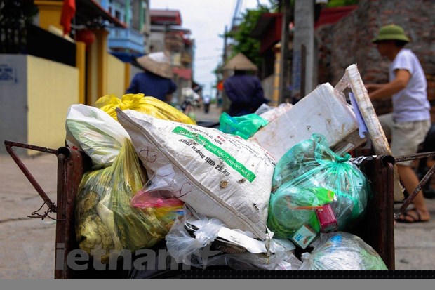 Việc thu gom rác tại các ngõ xóm dưới 2m tại các huyện ngoại thành Hà Nội đang gặp rất nhiều khó khăn. (Ảnh: Q.Sỹ/Vietnam+).
