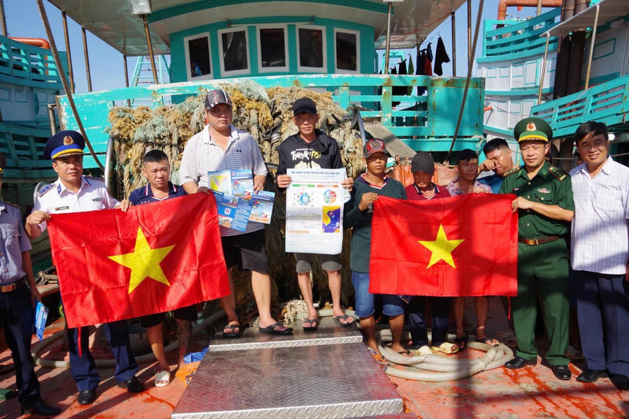 Lực lượng Bộ đội Biên phòng và Cảnh sát biển tặng cờ tổ quốc cho ngư dân.
