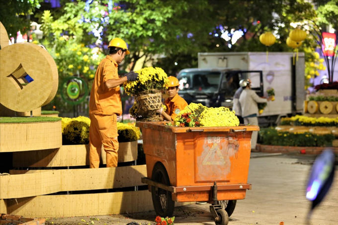 Công nhân khẩn trương tháo dỡ các tiểu cảnh trang trí trên đường hoa. Ảnh: Trường Sơn