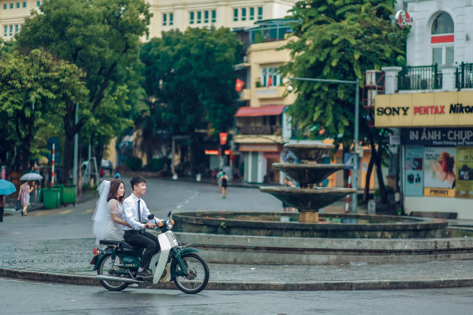 Một cặp đôi tranh thủ tái hiện bức ảnh Hà Nội xưa.